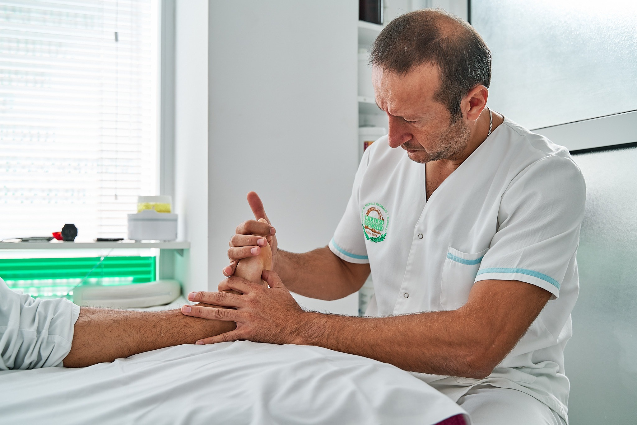 Especialista en reflexología podal haciendo masaje a paciente